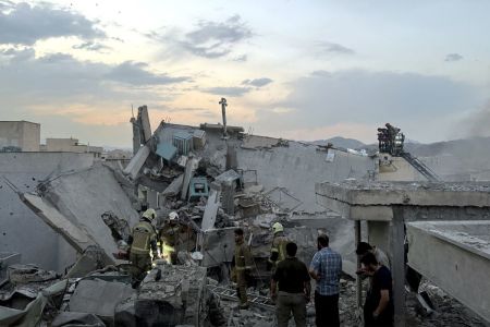 People and first-responders gather atop a building that was hit by an Israeli strike in Tehran on June 13, 2025. Israel hit about 100 targets in Iran on June 13, including nuclear facilities and military command centers and killing senior figures including the armed forces chief and top nuclear scientists.