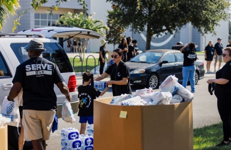 Volunteers with Celebration Church of Jacksonville, Florida, give groceries to the less fortunate as part of their annual Serve Day event.
