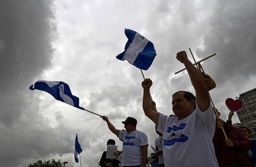 People wave Nicaraguan flags during a demonstration to protest against the political situation in Nicaragua at the Colon square in Madrid on June 10, 2018.
