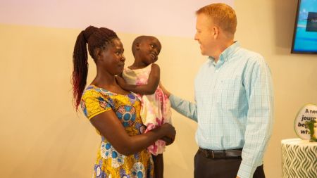 CURE Uganda Executive Director Tim Erickson (R) meets Rachael, 4, who had surgery for hydrocephalus, and received a Cub wheelchair through the collaboration between CURE International and Joni and Friends.