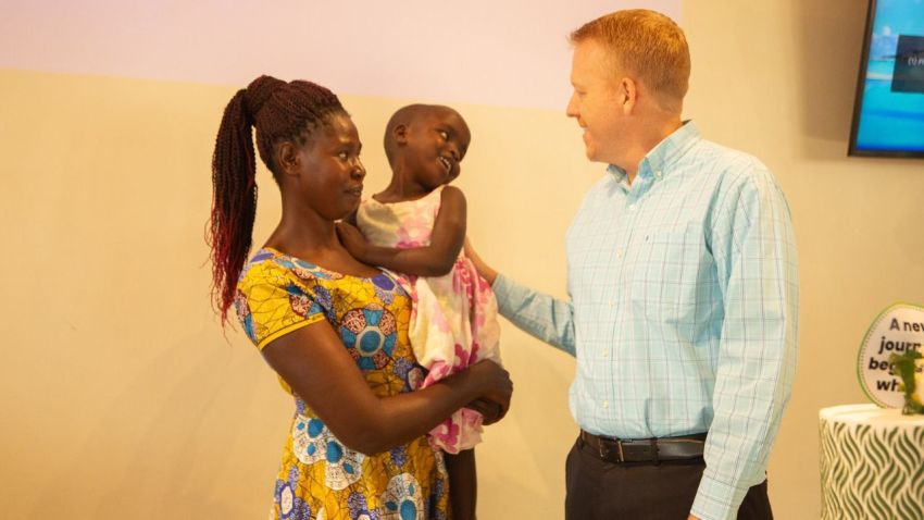 CURE Uganda Executive Director Tim Erickson (R) meets Rachael, 4, who had surgery for hydrocephalus, and received a Cub wheelchair through the collaboration between CURE International and Joni and Friends. 