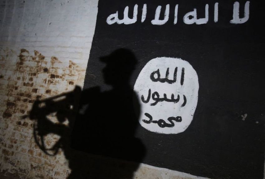 A member of the Iraqi forces walks past a mural bearing the logo of the Islamic State group in a tunnel that was reportedly used as a training center by the jihadists, on March 1, 2017, in the village of Albu Sayf, on the southern outskirts of Mosul. Iraqi forces launched a major push on February 19 to recapture the west of Mosul from the Islamic State jihadist group, retaking the airport and then advancing north.