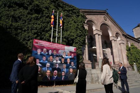The delegation from Save Armenia looks at a sign showing the 23 Armenian hostages held by the Azerbaijan government in Baku outside of a building in Yerevan, Armenia, that houses the government-in-exile of the Republic of Artsakh, on Sept. 24, 2025. 