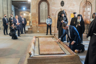 US Vice President JD Vance (R) kneels over the Unction Stone, believed to be the place where Christ's body was laid down after being removed from the crucifix and prepared for burial, as he tours the Church of the Holy Sepulchre in the Old City of Jerusalem on October 23, 2025.
