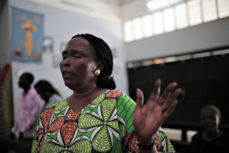 A Sudanese Christian woman prays during a Sunday service at the All Saints Cathedral in the Sudanese capital Khartoum on Aug. 18, 2019. Sudan's Christians suffered decades of persecution under the regime of Islamist general Omar al-Bashir. Now they hope his downfall will give the religious freedom they have long prayed for.