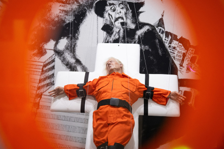 This photograph shows the art piece by British artist Mason Storm called "Saint or Sinner," depicting U.S. President Donald Trump dressed in an orange prison jumpsuit on a cross, displayed at an exhibition space in Basel, Switzerland, on Nov. 3, 2025.