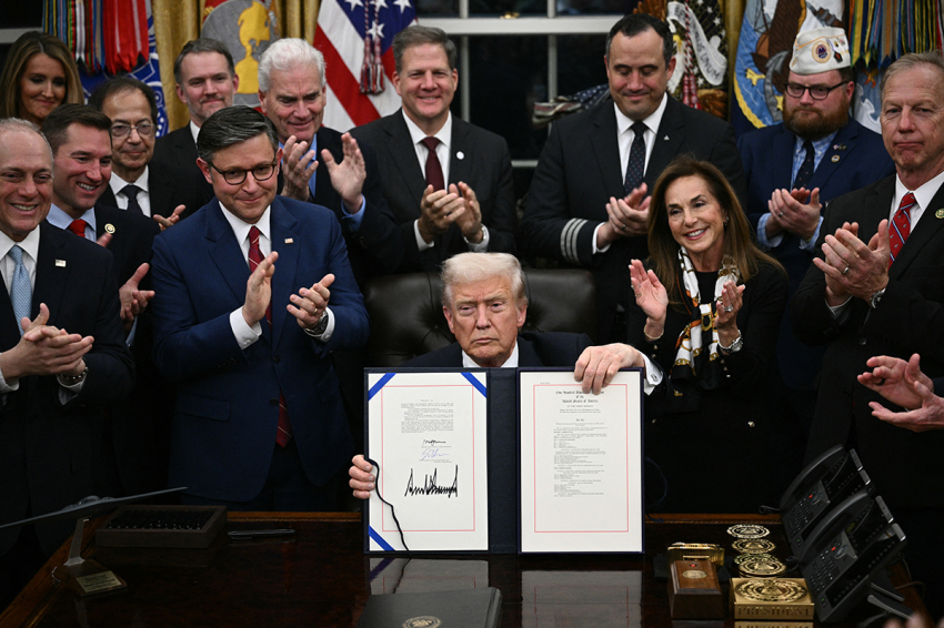 U.S. President Donald Trump shows the signed bill package to re-open the federal government in the Oval Office of the White House in Washington, D.C., on Nov. 12, 2025. 