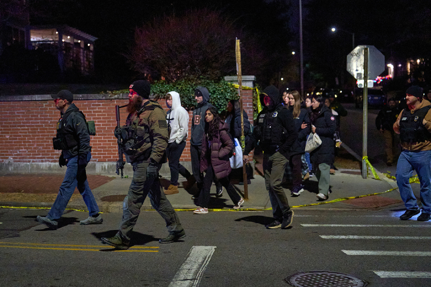 Law enforcement officers escort students near the Barus & Holley engineering building at Brown University campus in Providence, Rhode Island, on Dec. 13, 2025. A gunman killed two people and critically wounded nine others in the afternoon of Dec. 13 at prestigious Brown University, authorities said, urging people in the area to remain in lockdown as the attacker was still at large. 