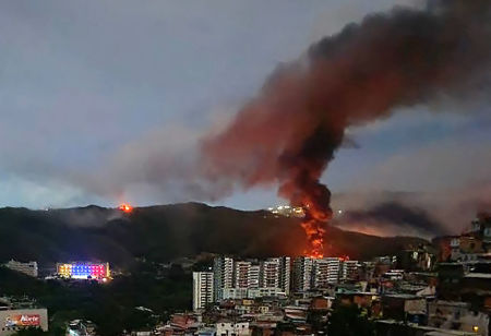 Fire at Fuerte Tiuna, Venezuela's largest military complex, is seen from a distance after a series of explosions in Caracas on Jan. 3, 2026. The United States military was behind a series of strikes against the Venezuelan capital Caracas.
