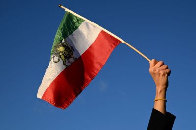 A protester waves a pre-1979 Islamic Revolution Iranian flag during a demonstration against the Iranian regime's crackdown on protests in central Paris, on Jan. 4, 2026. Several hundred people gathered on January 4, 2026 at two rallies in Paris in support of the week-long protest movement in Iran.