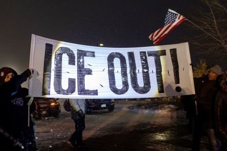 Protesters with a large anti-ICE sign, stand outside of the Henry Bishop Whipple Federal building on January 18, 2026, in Minneapolis, Minnesota. Protesters continued to gather to demonstrate against an ongoing immigration enforcement dubbed "Operation Metro Surge."