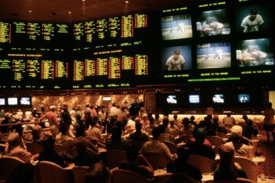 Gamblers bet on a variety of sporting events, such as baseball and boxing, as highlights flash on the screens in the Sports Book, the betting lounge at the Mirage casino in Las Vegas.