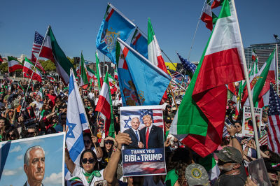 A man holds pictures of Reza Pahlavi, son of the former Shah of Iran while another man holds a photo of the Israel Prime Minister Benjamin Netanyahu and the US President Donald Trump as People wave Iranian pre-1979 Islamic Revolution while members of the Iranian community celebrate in front of the Federal Building on March 1, 2026 in Los Angeles, California. U.S. President Donald Trump announced that the United States and Israel had launched an attack on Iran Saturday morning.