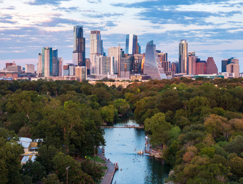 Aerial view of the Austin skyline at sunset over Barton Springs in Austin, Texas. 
