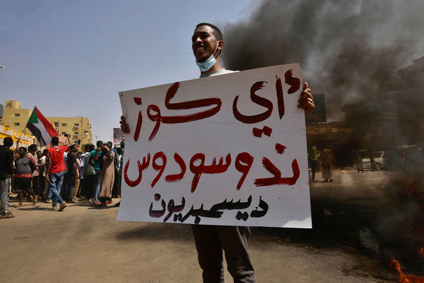 A Sudanese demonstrator holds a placard during a protest in the city of Khartoum Bahri, the northern twin city of the capital, to demand the government's transition to civilian rule, on Oct. 21, 2021. The placard reads in Arabic