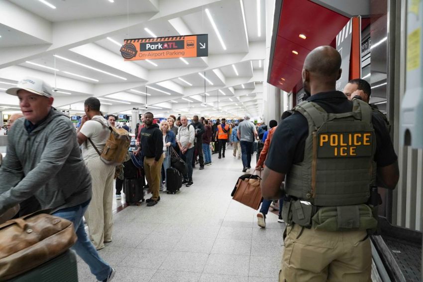 Federal agents look on as travelers stand in long lines at Atlanta Hartsfield-Jackson International Airport on March 23, 2026, in Atlanta, Georgia. The travel disruptions continue as hundreds of TSA agents quit or work without pay during a partial government shutdown. U.S. President Donald Trump said ICE agents will be deployed to U.S. airports on Monday, with border czar Tom Homan in charge of the effort. 