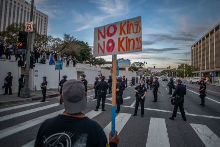 A man holds a sign near the Metropolitan Detention Center to protest immigration enforcement and Federal overreach during a national "No Kings" protest on March 28, 2026 in Los Angeles, California. This is the third nationwide "No Kings" protest held against the Trump administration.