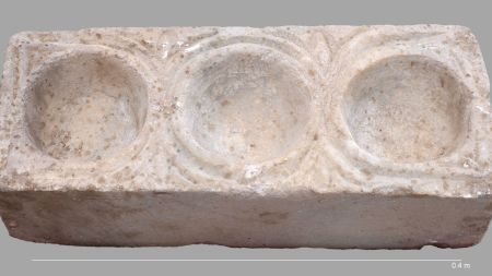 The rectangular marble block with three hemispheric cavities for oils.