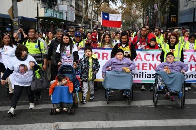 Camila Gomez (C) leads a march on her way to the Palacio de La Moneda to meet with Chilean President Gabriel Boric in Santiago on May 29, 2024. Camila Gomez walked the 1,300 kilometers from Ancud, Chiloé, to Santiago on April 28 to raise 3.5 million dollars for her son Tomas's medical treatment, who suffers from Duchenne muscular dystrophy (DMD).