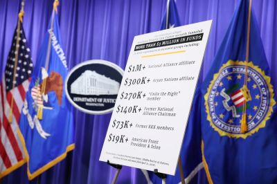 A poster is displayed before a news conference with the Acting U.S. Attorney General Todd Blanche and Federal Bureau of Investigation (FBI) Director Kash Patel at the Robert F. Kennedy Department of Justice building on April 21, 2026 in Washington, DC. Blanche and Patel held the news conference to announce charges against to the Southern Poverty Law Center, in which they allege the center funneled over $3 million dollars into the pockets of white supremacist and extremist groups.