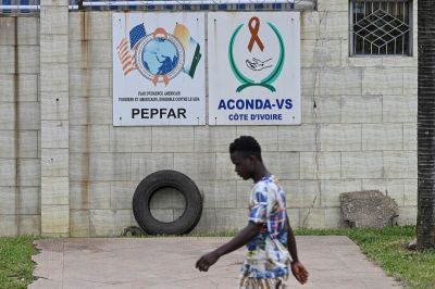 A pedestrian walks past a PEPFAR sign in Abidjan on July 12, 2025.