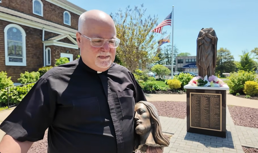 The Rev. Anthony Iaconis holds the beheaded Sacred Heart of Jesus statue at the Church of St. Mary in East Islip, New York. 