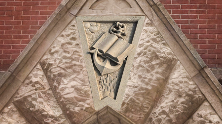 A salvaged stone from the original First Dallas Baptist sanctuary featuring a carved Bible and anchor.