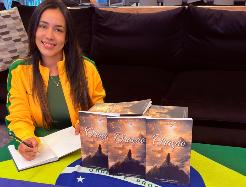 Stefania Leão poses with copies of the Brazilian Portuguese edition of The Prayer: Rise with Jesus — 30 Days to Transform Your Life, which she co-authored with Alexander Debelov.
