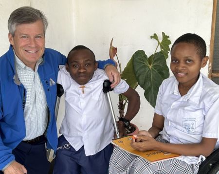 Faraja Fund Foundation Chairman David Tolmie interacting with two students from the Faraja Primary School.