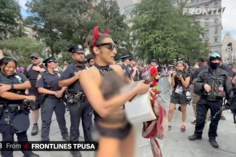 Scantily-clad trans activist wielding crucifix rips out pages of the Bible at 9/11 protest