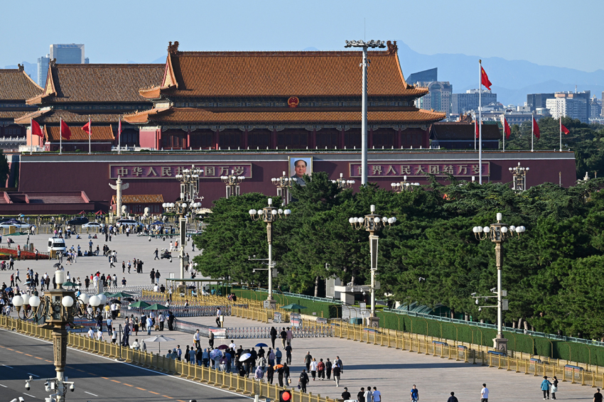 The portrait of China's late Communist leader Mao Zedong which hangs on Tiananmen Gate (top C) is seen behind people in Tiananmen Square on the 50th anniversary of Mao's death in Beijing on Sept. 9, 2026.