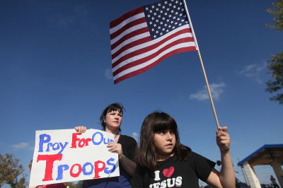 Kendra Thomas (L) and her daughter, Sophia Thomas, 7, show their support on at the front gate to Fort Hood where U.S. Army Major Nidal Malik Hasan went on a shooting rampage at the Soldier Readiness Center on Nov. 5, 2009, in Killeen, Texas. Kendra said on Nov. 7, "I just want to let the soldiers know they are not standing alone." Hasan, an Army psychiatrist, killed 13 people and wounded 32 in a shooting at the military base.