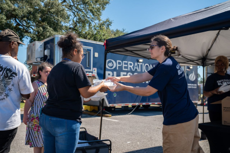 An Operation Blessing volunteer gives a meal to a resident of the Florida Gulf Coast after Hurricane Isaias.