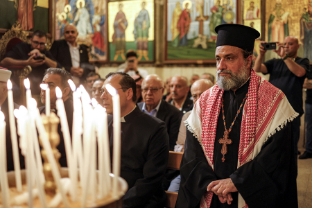 A priest wearing a Jordanian keffiyeh scarf attends a memorial service at the Greek Orthodox Church of the Transfiguration in the Palestinian city of Ramallah in the West Bank, on Oct. 26, 2026, in solidarity with the victims of an attack on the Church of St George in Jordan's village of Hammoud on Oct. 23. On Oct. 23, gunmen stormed the compound of the Greek Orthodox St George's Church in the village of Hammoud in Karak governorate during a funeral procession, killing nine. Karak is home to a significant Christian community in Muslim-majority Jordan, where Christians make up between 2% and 3% of the population.