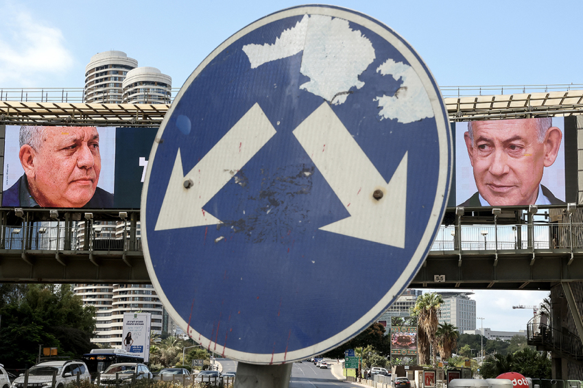 A road sign stands in front of a large billboard featuring Israel's Prime Minister Benjamin Netanyahu (R) of the Likud Party and former military chief and leader of the centrist Yashar Party, Gadi Eisenkot, in Ramat Gan on Oct. 20, 2026. Israel heads to the polls on Oct. 27 in its first election since the Oct. 7, 2023, Hamas-led attack, in what is seen as a referendum on the prime minister. (Photo by Jack GUEZ / AFP via Getty Images)