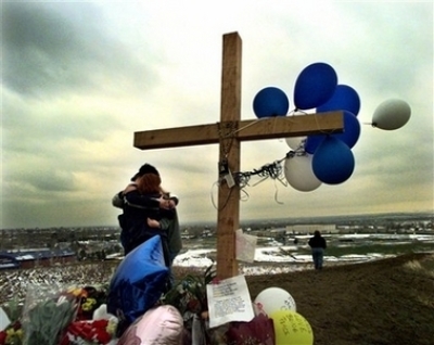 Unidentified students embrace each other at a makeshift memorial for their slain classmates at Columbine High School on a hilltop overlooking the school in Littleton, Colo., in this April 24, 1999, file photo. Twelve students and a teacher were killed in a murderous rampage at the school on April 20, 1999, by two students who killed themselves in the aftermath.