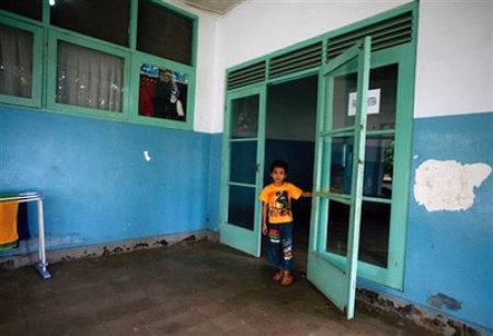 An Indonesian boy looks out from the door to a group of bedrooms Friday June 20, 2008 at an orphanage in Jakarta, Indonesia.