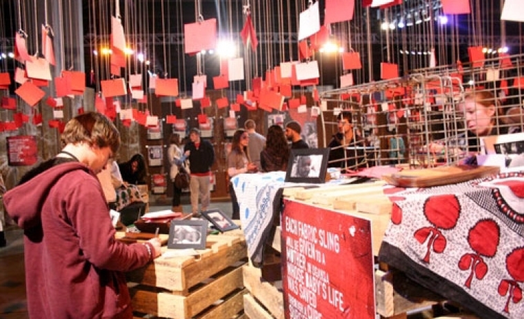 Red cards hang from the rafters at the Cure International station where Passion 2011 students are asked to donate towards life-saving surgery for a baby in Uganda. Each card contains a student message to the babies who suffer from Hydrocephalus, or "water on the brain," which causes swelling of the head and results in developmental delay, blindness, and eventually death. Instead of just meeting the goal of raising ,000 to fund 50 surgeries, students provided 1,000 to save the lives of 141 babies.