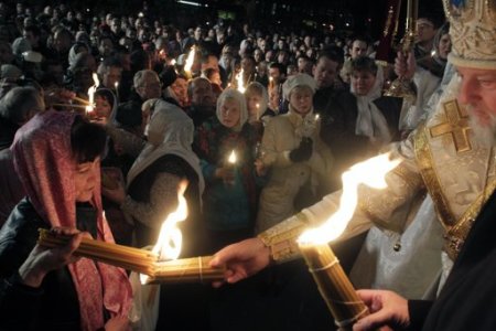 Orthodox believers light candles with "holy fire", lit on Orthodox Easter Day in the Church of the Holy Sepulchre in the Old City of Jerusalem and taken to Latvia, during an Orthodox Easter service in Riga April 14, 2012.