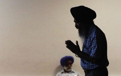 A man holds his hands in prayer as he walks inside the Sikh Cultural Society in the Queens borough of New York August 6, 2012.
