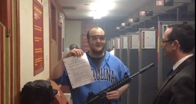 A gun enthusiast holds up a copy of Missouri bill 545, which he used for target practice, in a YouTube video entitled "2nd Amendment Puts Holes in HB 545."