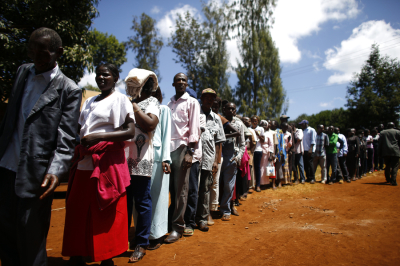 People wait in line to cast their ballots in front of a polling station in Kenya's town of Gatundu March 4, 2013. Polling stations opened up to Kenyans on Monday for a tense presidential election that will test whether the east African nation can repair its damaged reputation after the tribal blood-letting that followed a 2007 poll.