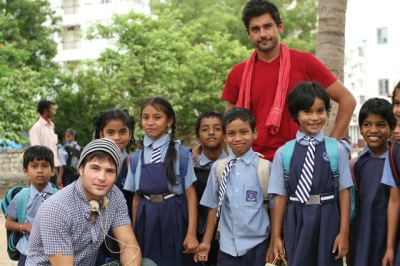 Actors Cody Longo (lower) and Walid Amini on set with schoolchildren in India during the production of the 2013 movie "Not Today."
