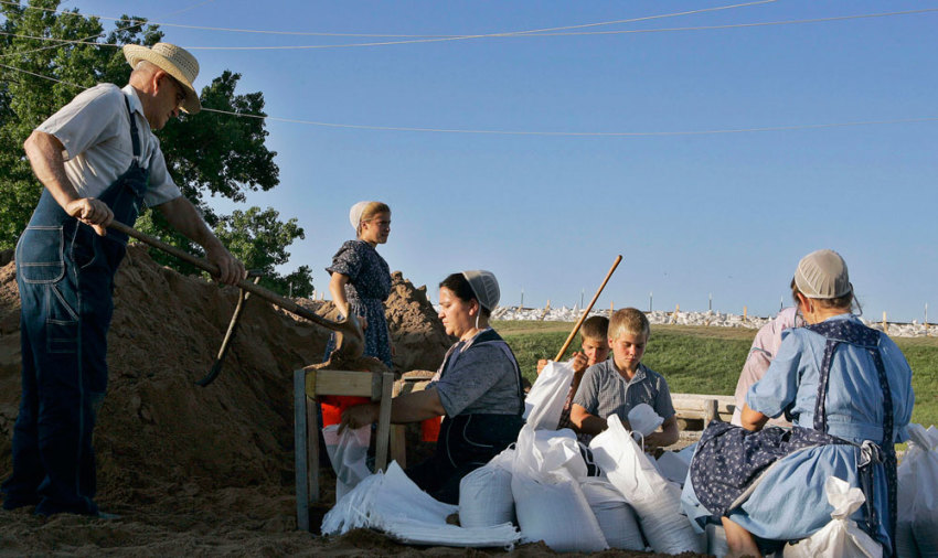 Members of an Amish community fill sandbags to be placed along the levy in Canton, Missouri, in this June 17, 2008 file photo. America's Amish population has nearly doubled and spread out in the past 16 years due to large families, more marriages within the community and longer lifespans, a study showed on August 20, 2008.