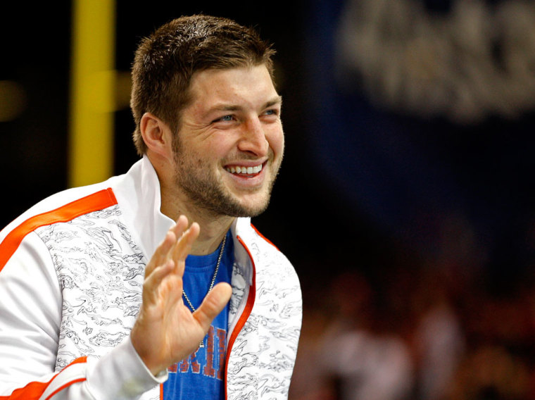 Former Florida Gators quarterback Tim Tebow waves as he stands on the sidelines before the Gators play against the Louisville Cardinals in the 2013 Allstate Sugar Bowl NCAA football game in New Orleans, Louisiana January 2, 2013.