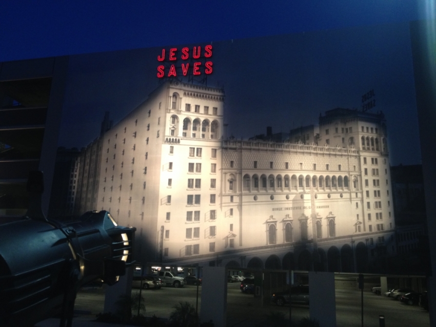 A smaller replica of the iconic "Jesus saves" sign is incorporated into a giant mural on the side of a Biola University parking structure.