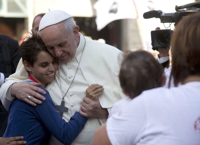 Pope Francis hugs a girl