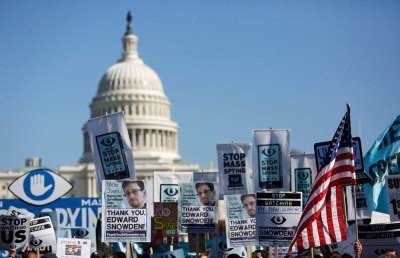 Demonstrators hold up their signs during the "Stop Watching Us: A Rally Against Mass Surveillance" march near the U.S. Capitol in Washington, October 26, 2013.