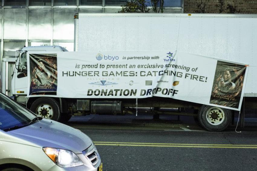 Last week, BBYO, a Jewish teen organization, organized prescreenings of the new film "The Hunger Games: Catching Fire," but with a twist – they teamed up with local food banks and asked for food donations. Across the country, Jewish teens in this effort donated over 17,000 pounds of food. This poster advertises the screening in Detroit, Michigan, which attracted 595 teens and collected 1,100 pounds of food.