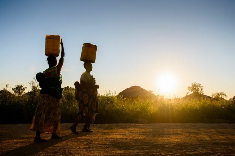 Women carry water home in Mozambique.